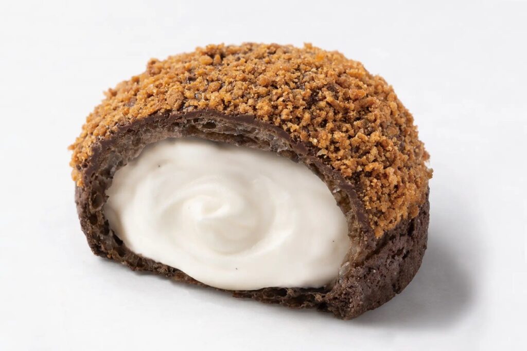 「ブラックモンブランシュー」の断面。チョココーティングのザクザク生地に、なめらかなバニラ風味のクリームがたっぷり詰まっている様子。
