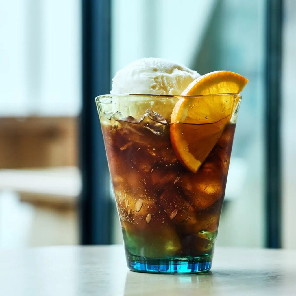 UTSUWA EXPERIENCE「朝陽のきらめき」。琉球グラスに注がれたコールドブリューとオレンジ、バニラアイスの華やかなドリンク。