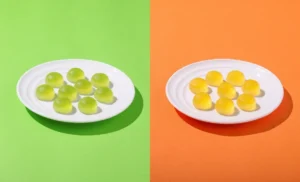 シャインマスカット味（左）とマンゴー味（右）の「セブンプレミアム グミまる」が白い皿に盛られ、カラフルな背景で並ぶイメージカット。