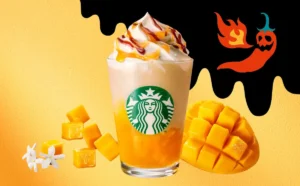 スターバックスの新作『ホットハニー オリエンタル マンゴー & ティー フラペチーノ®』のイメージ画像。マンゴー果肉とホイップクリーム、辛さを象徴する炎と唐辛子のイラストが夏の刺激を演出している。