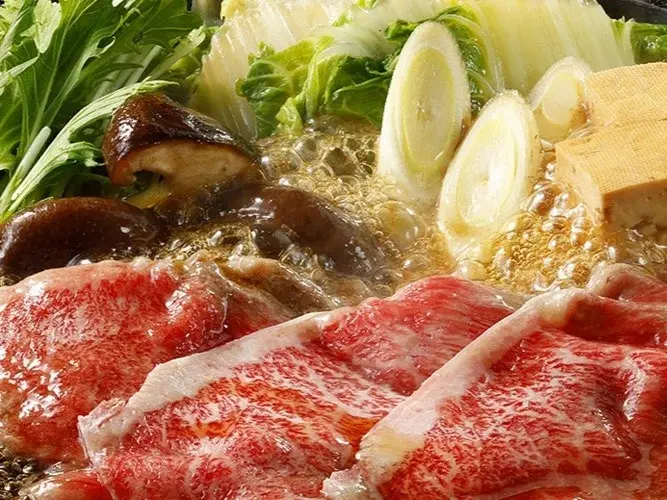 たまり醤油と黒糖のすき焼きだしで具材を煮込む様子。味がしみ込んだ野菜と牛肉