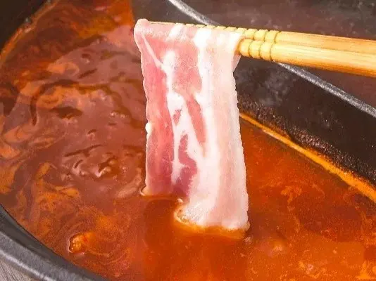 四川豆板醤の旨辛火鍋だしに豚肉をしゃぶしゃぶ。ピリ辛で食欲をそそる味わい