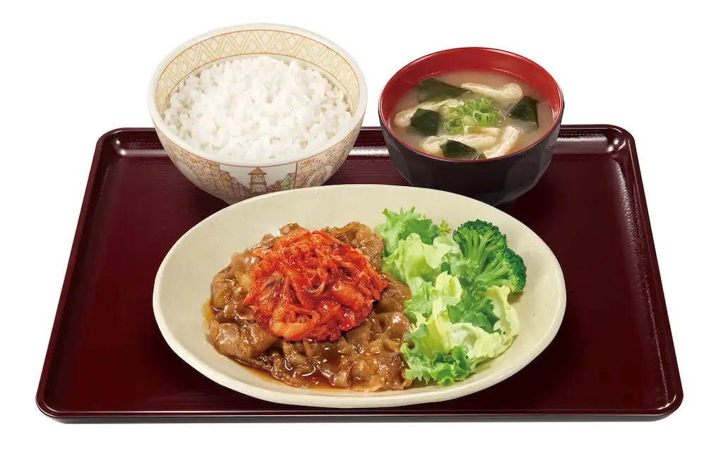 すき家『キムチ牛カルビ焼肉定食』のセット。ピリ辛キムチが牛カルビの上に盛られ、ごはん・みそ汁・野菜がつくバリエーション