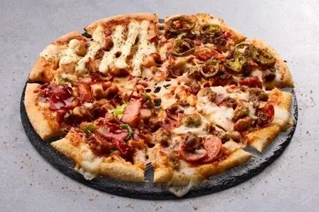 4種類の世界の肉ピザを1枚に集めた「ワールドドミノ 北南米編」。チョリソーやBBQ、チキン、ミートが豪快にトッピングされている。