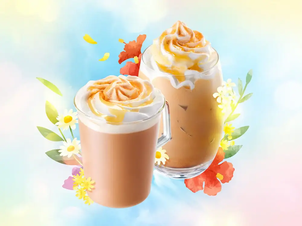 スターバックスの「アールグレイ ブーケ & ティー ラテ(ホット/アイス)」のイメージビジュアル。ホイップと柑橘パウダーがトッピングされたラテに、花々が彩りを添える。